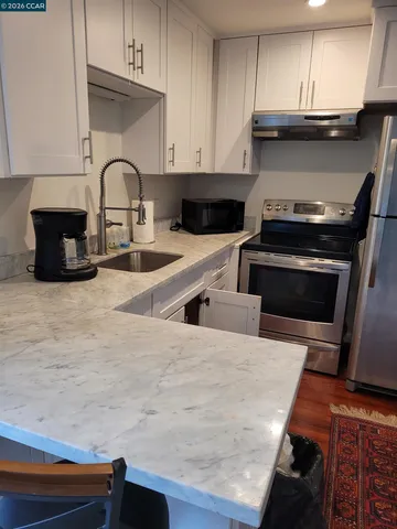 a kitchen with granite countertop a stove and a sink