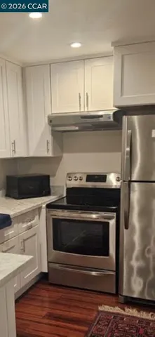 a kitchen with stainless steel appliances granite countertop a stove a microwave and a refrigerator