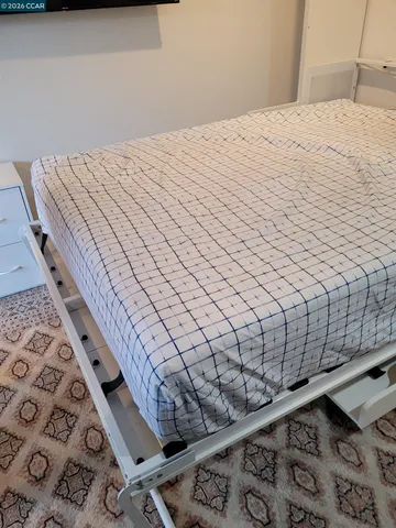 a bed sitting in a bedroom next to a window