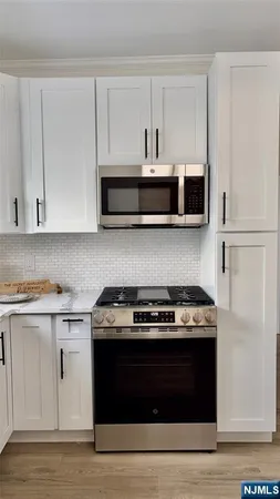a kitchen with stainless steel appliances granite countertop a stove and a microwave