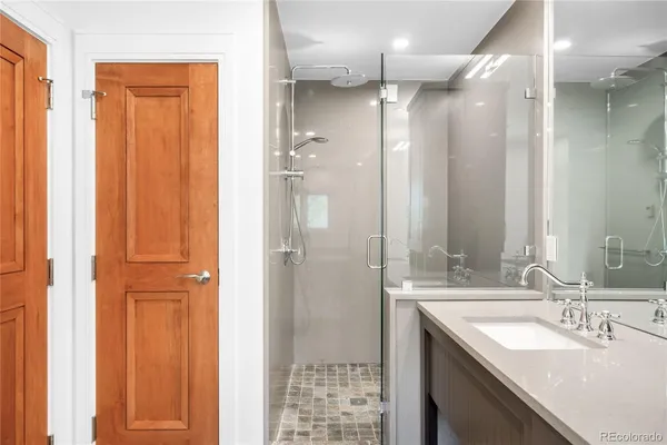 a bathroom with a granite countertop sink shower and a mirror