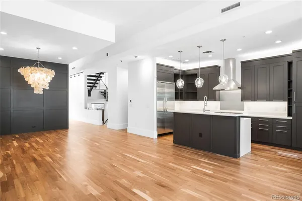 a kitchen with stainless steel appliances kitchen island granite countertop a refrigerator a sink dishwasher and a wooden cabinets