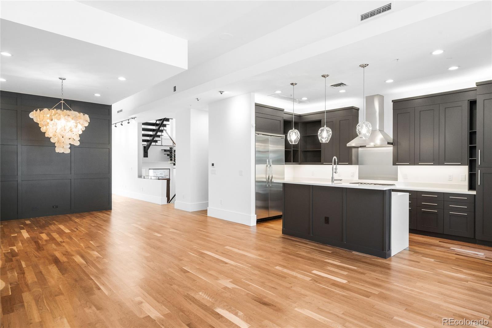 2133 18th Street, Unit RL Denver, CO 80202 - Photo 3 of 46 a kitchen with stainless steel appliances kitchen island granite countertop a refrigerator a sink dishwasher and a wooden cabinets