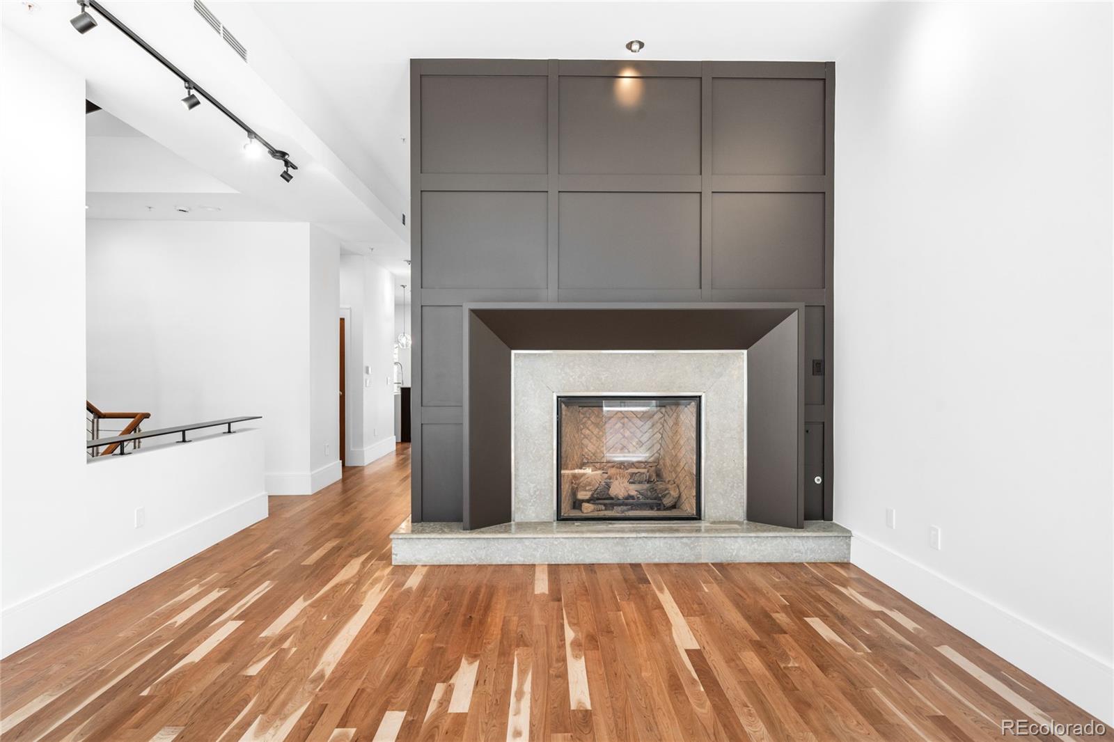 2133 18th Street, Unit RL Denver, CO 80202 - Photo 4 of 46 a view of an empty room with wooden floor and a fireplace