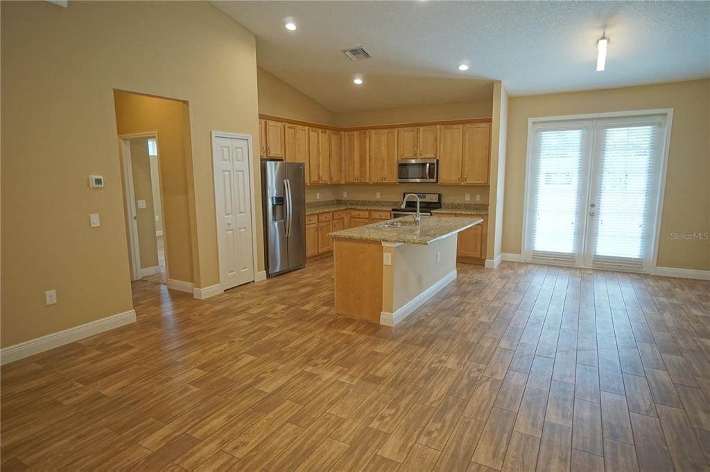 3525 West Ballast Point Boulevard Tampa, FL 33611 - Photo 11 of 25 a large kitchen with stainless steel appliances a large counter top a stove and a wooden floors
