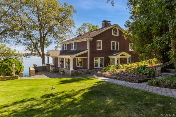 a view of a house with a big yard and large trees