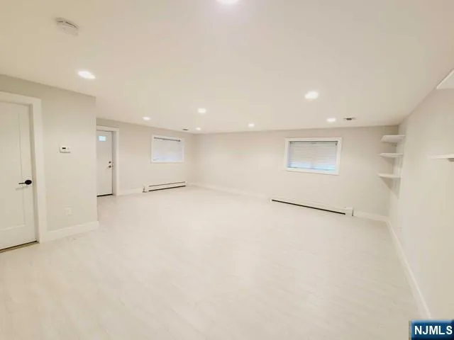 an empty room with a cabinet and mirrors