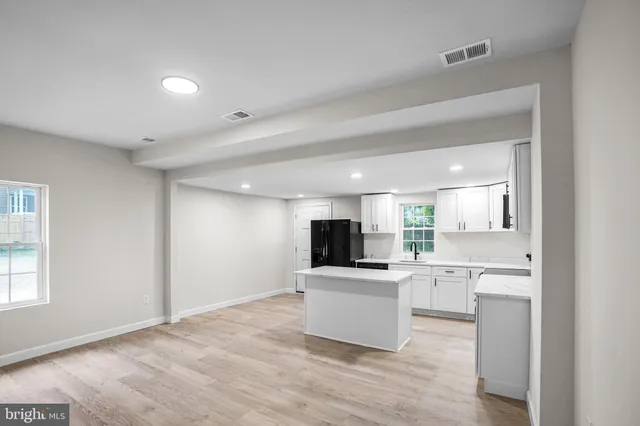 a kitchen with a sink stainless steel appliances and white cabinets
