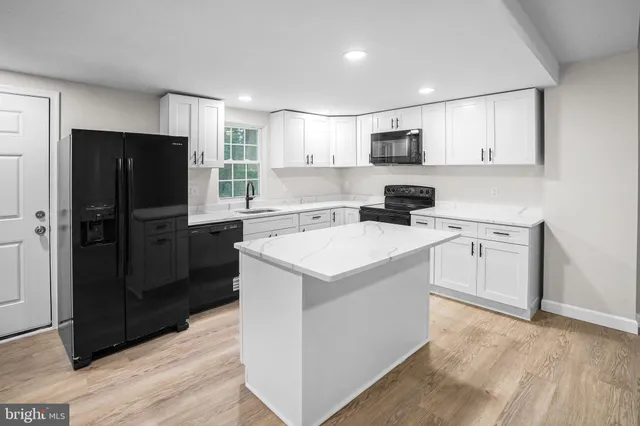 a kitchen with a sink refrigerator and microwave