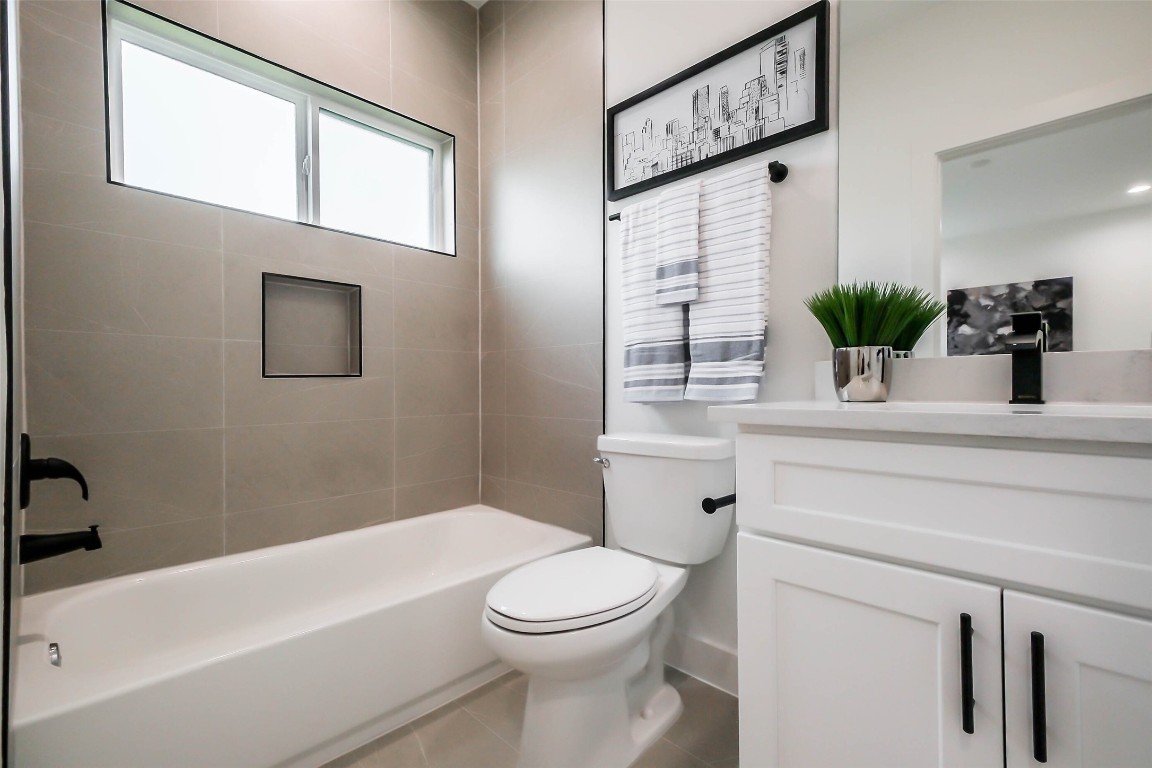5703 B Balbo Street Houston, TX 77091 - Photo 25 of 46 a bathroom with a toilet a sink a mirror and bathtub