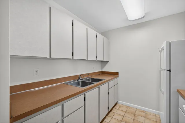 a bathroom with a bathtub shower sink vanity mirror and toilet