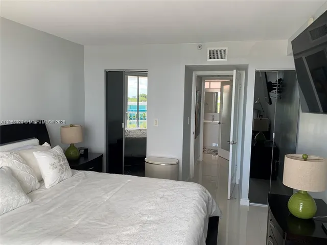 a bedroom with a bed and large windows