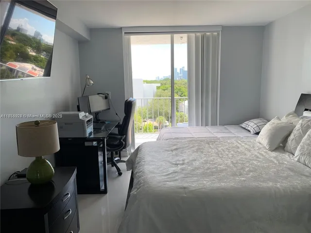 a vase of flowers sitting on a floor in front of a house