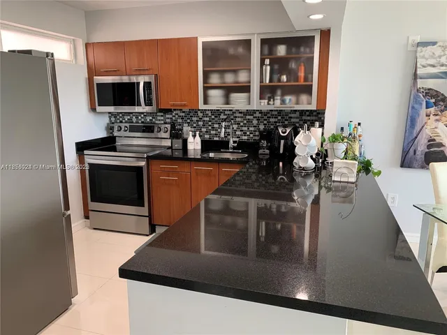 a kitchen with stainless steel appliances granite countertop a stove a sink and a refrigerator