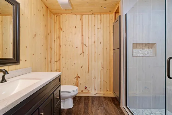 a bathroom with a granite countertop sink a toilet and shower