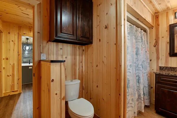 a bathroom with a granite countertop toilet and a shower