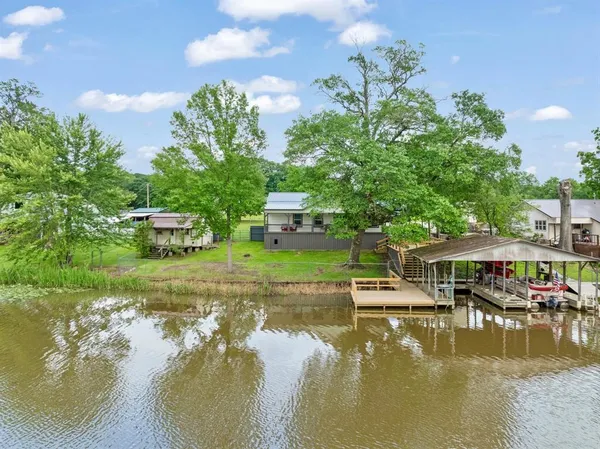 a view of house with swimming pool and trees in the background