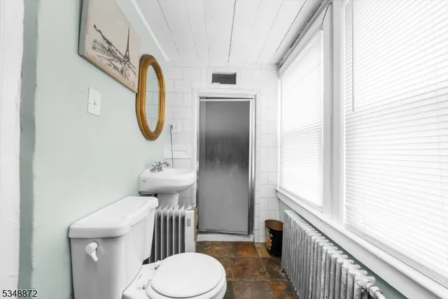 a bathroom with a sink a toilet and a mirror