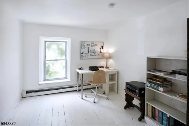 a view of a workspace with furniture and a window