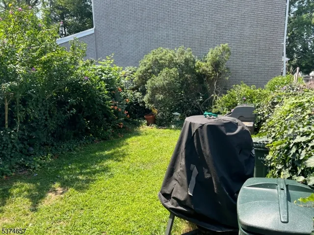 a view of a yard with a slide and a wooden fence