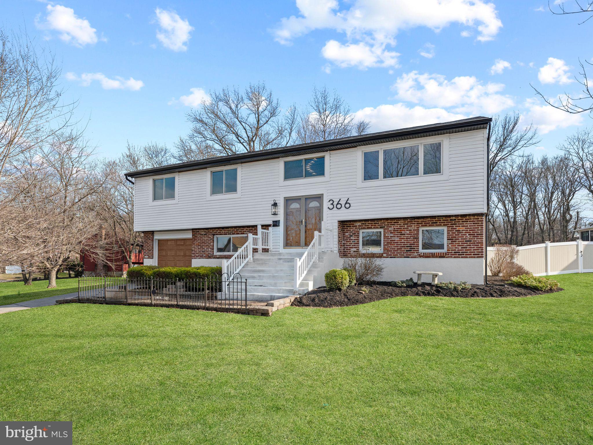a front view of a house with a yard and outdoor seating