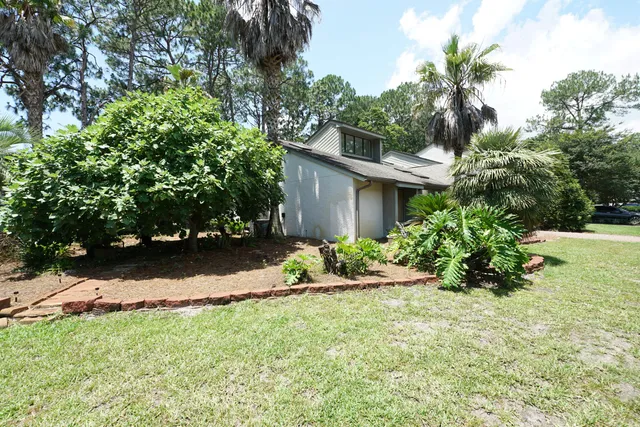 a view of a house with a yard and potted plants