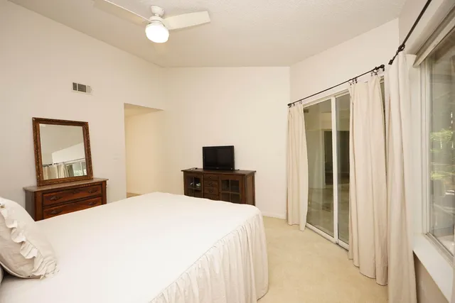 a bedroom with a bed and a flat tv screen on the dresser
