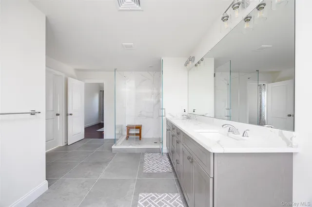 a spacious bathroom with a bathtub a sink and a mirror