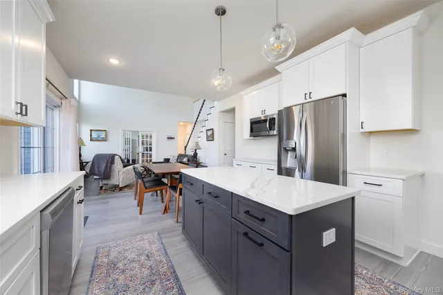 a large kitchen with stainless steel appliances lots of counter space sink refrigerator and furniture