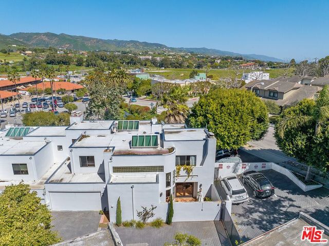 an aerial view of residential houses with outdoor space and city view