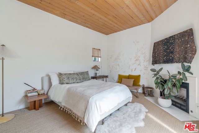 a bedroom with bed and a potted plant