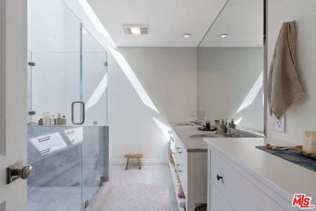 a en suite bathroom with a double vanity sink and a mirror