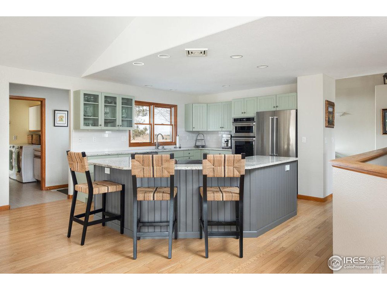 8923 Sage Valley Road Longmont, CO 80503 - Photo 15 of 40 a kitchen with stainless steel appliances wooden floor and dining table