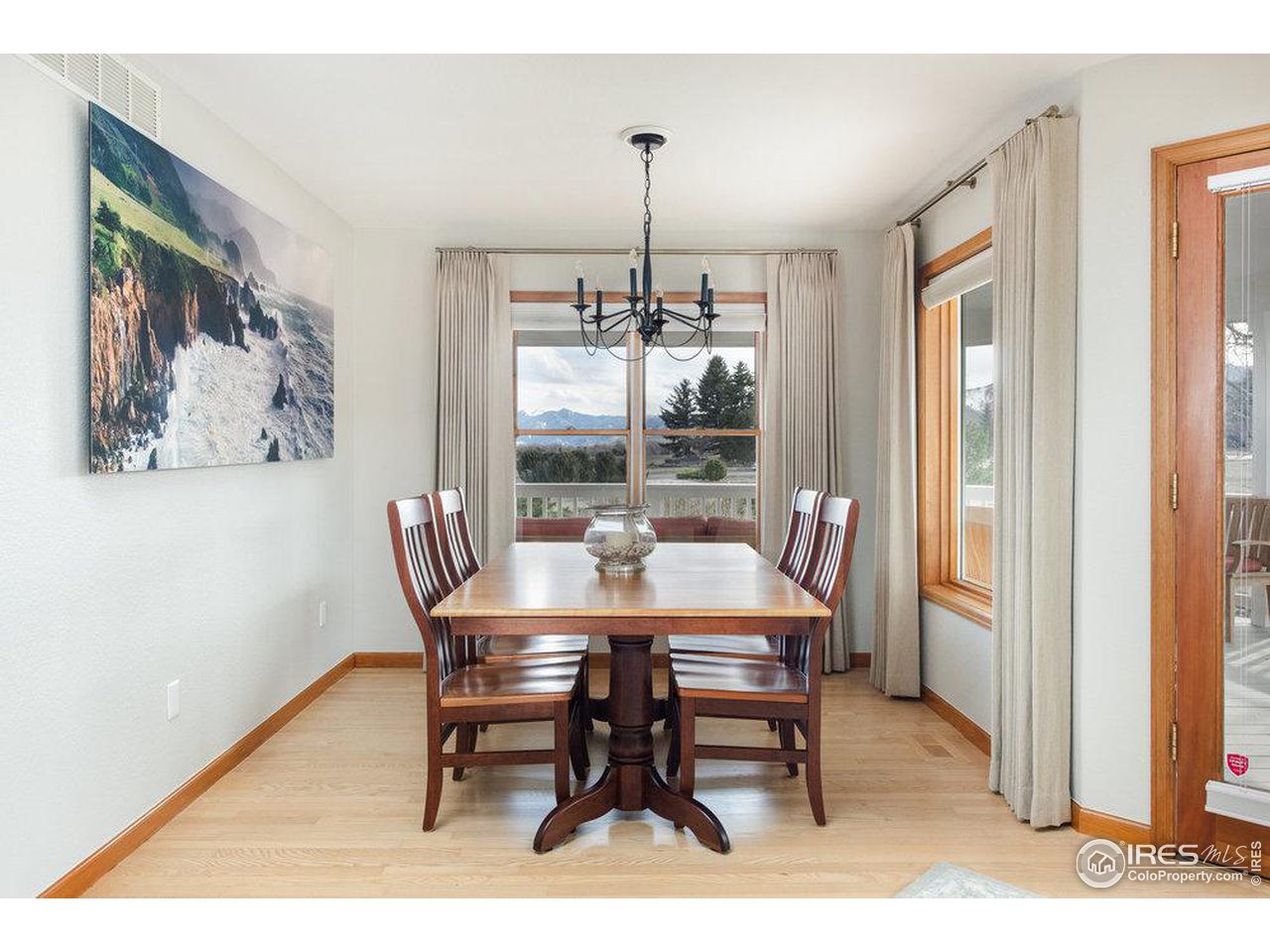 8923 Sage Valley Road Longmont, CO 80503 - Photo 16 of 40 a dining room with furniture a chandelier and wooden floor