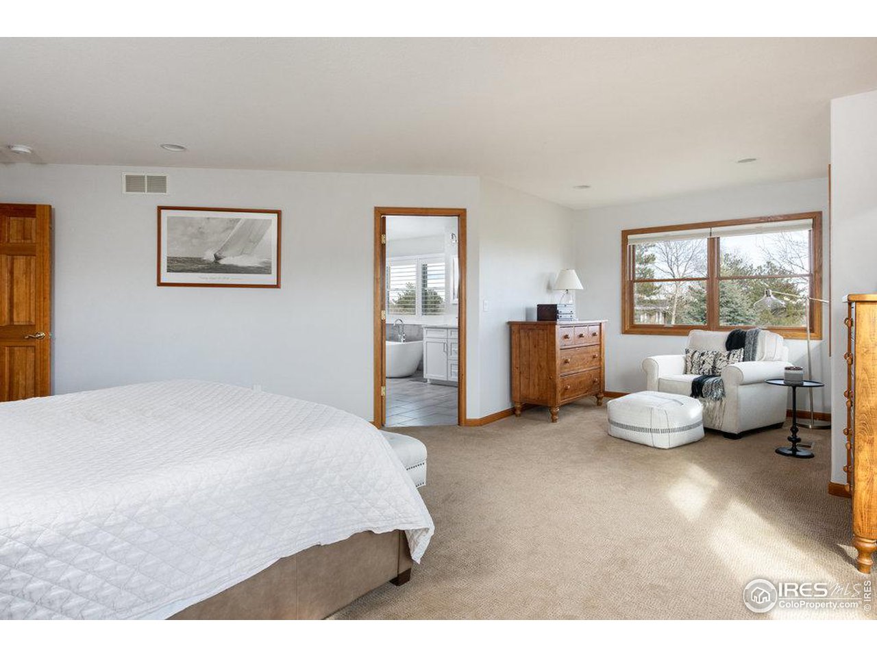 8923 Sage Valley Road Longmont, CO 80503 - Photo 28 of 40 a bedroom with a bed couch and a large window