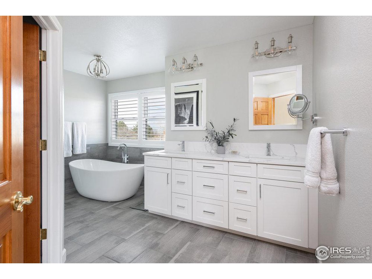 8923 Sage Valley Road Longmont, CO 80503 - Photo 29 of 40 a spacious bathroom with a double vanity sink a mirror and a bathtub