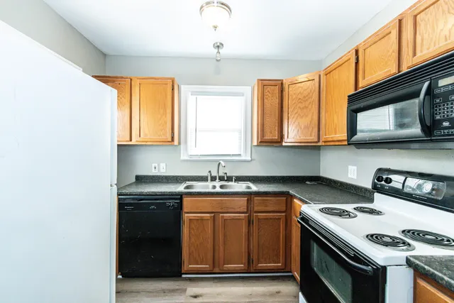 a kitchen with stainless steel appliances granite countertop a stove a sink and a microwave