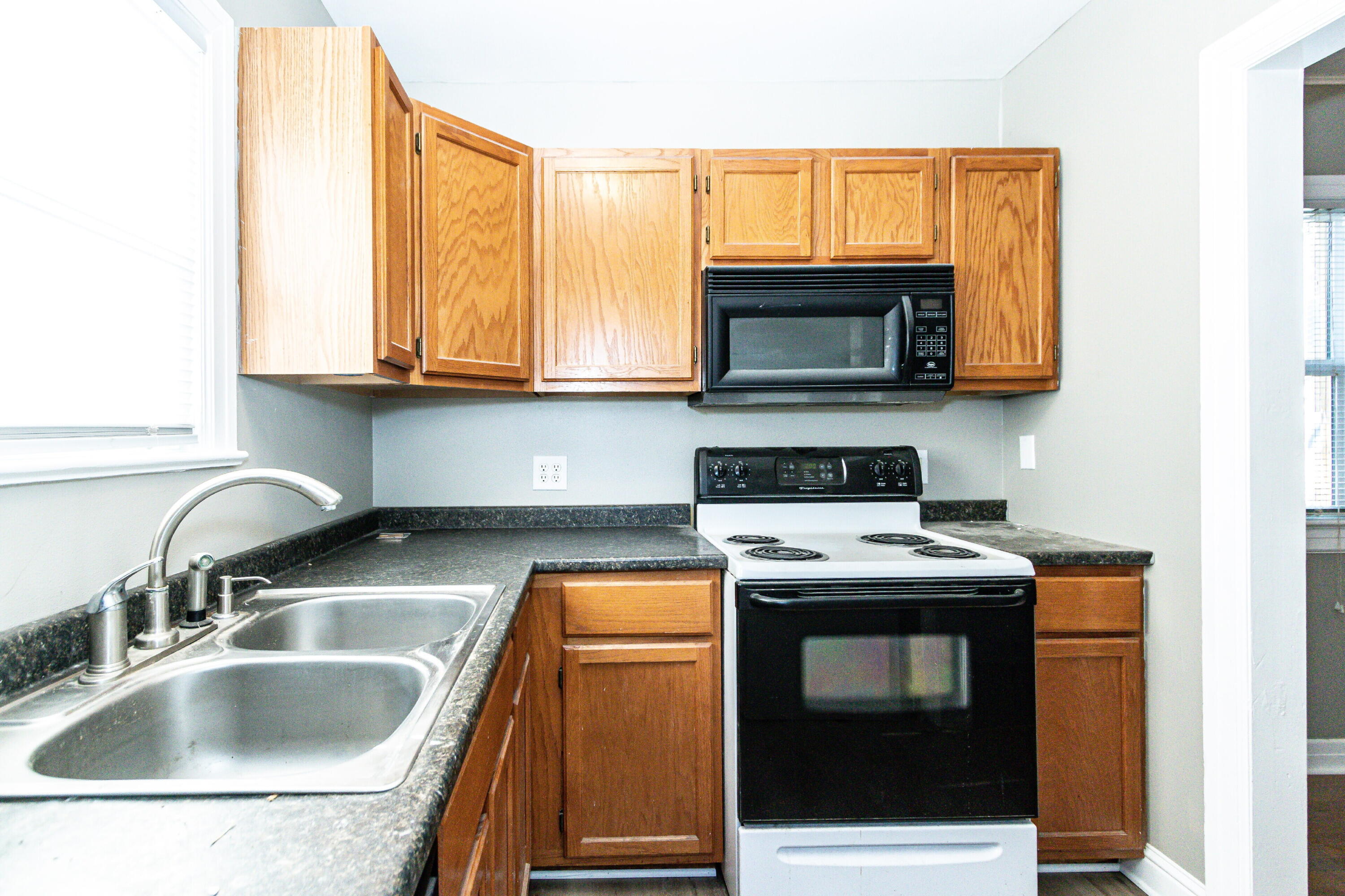 2417 25th Street Lubbock, TX 79411 - Photo 13 of 25 a kitchen with granite countertop a sink stove and microwave