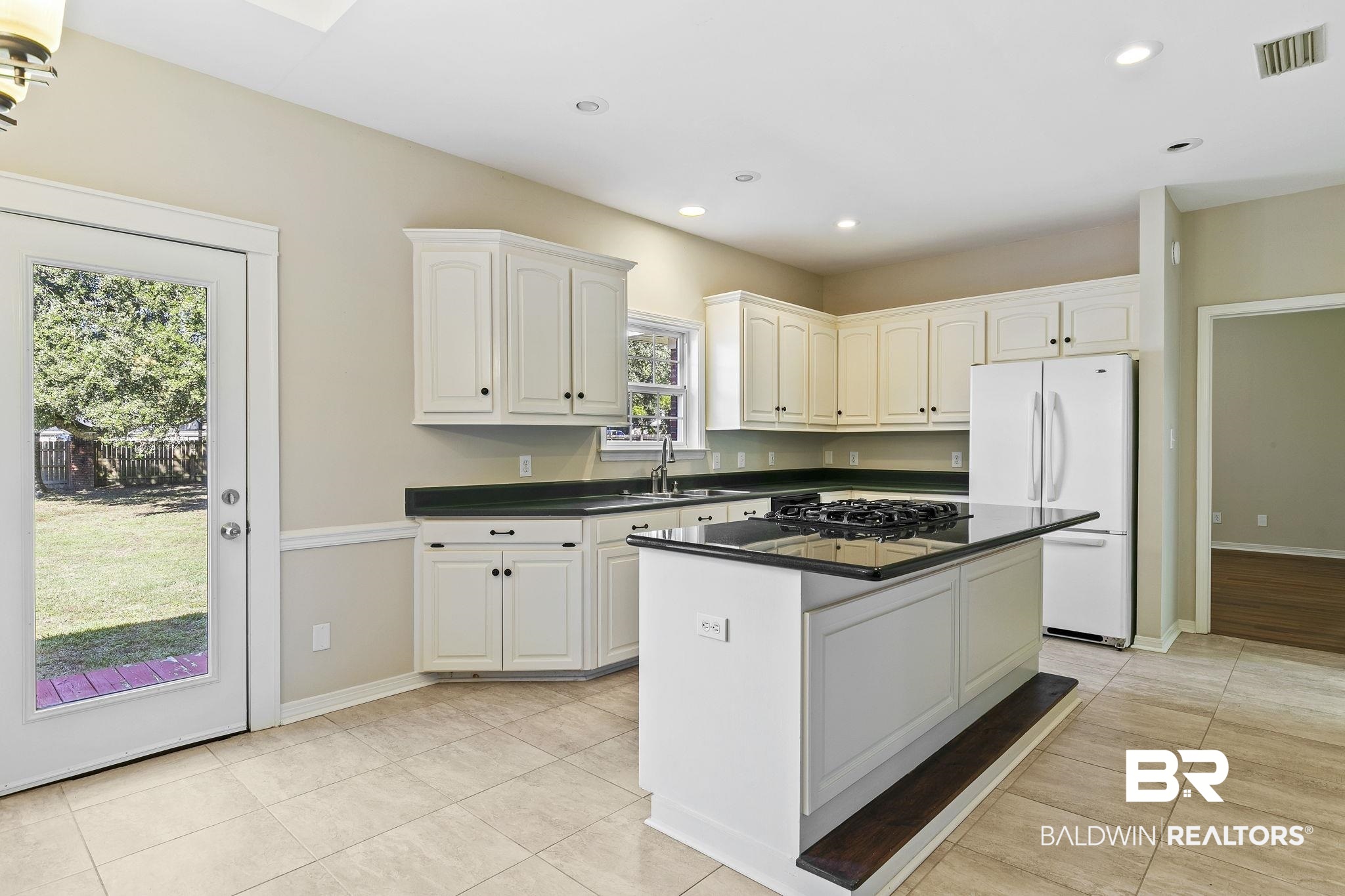 9631 Bay Meadows Avenue Fairhope, AL 36532 - Photo 13 of 49 Kitchen with a wealth of natural light, a center island, white cabinets, and white refrigerator