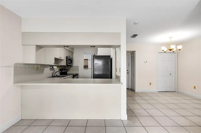 a view of a kitchen with stainless steel appliances a refrigerator and a sink