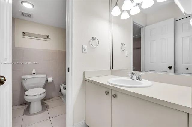 a bathroom with a granite countertop sink a toilet and a mirror
