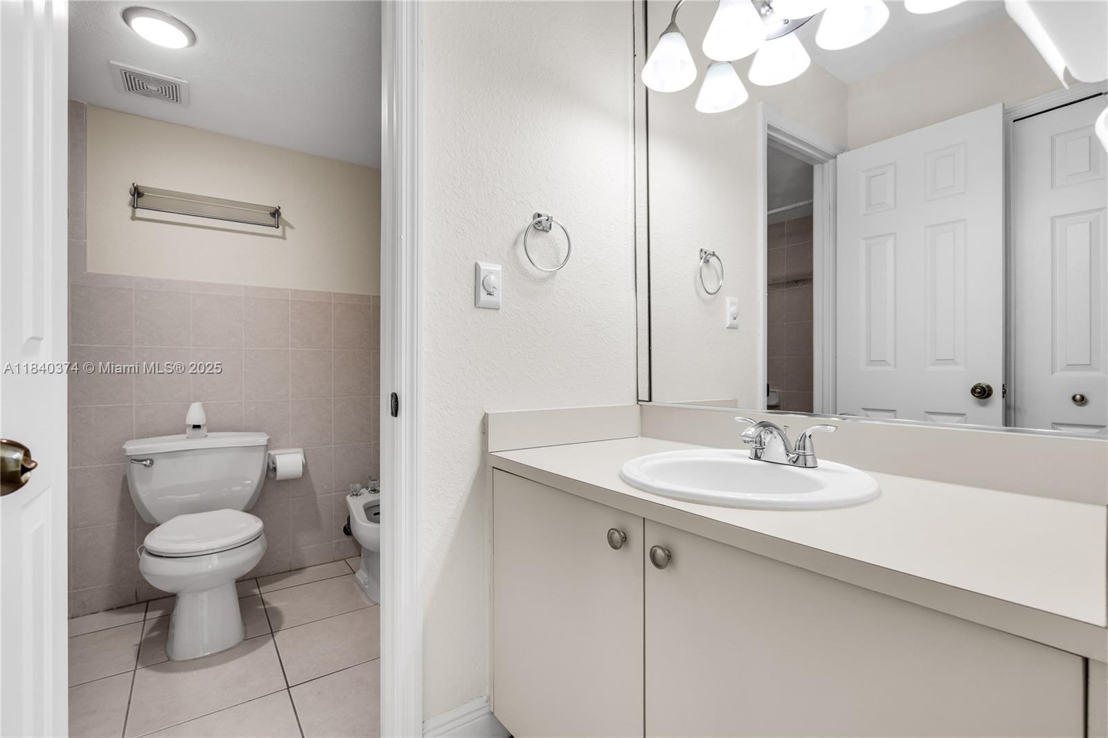 8425 Northwest 8th Street, Unit 304 Miami, FL 33126 - Photo 22 of 29 a bathroom with a granite countertop sink a toilet and a mirror