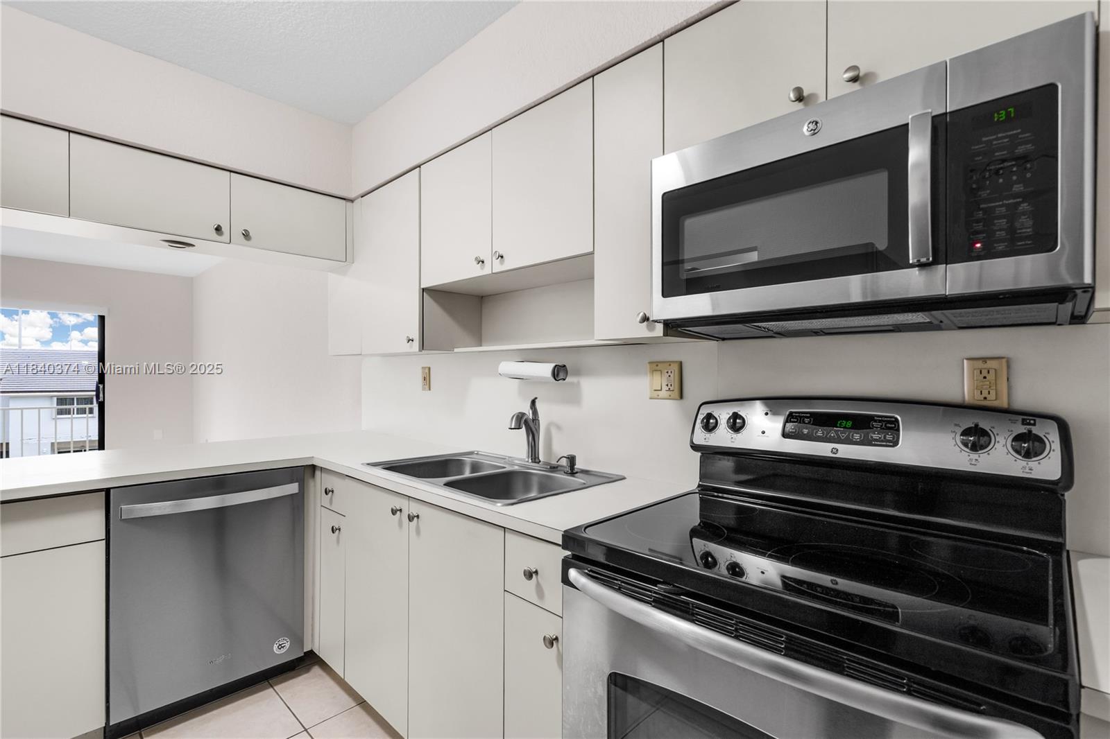 8425 Northwest 8th Street, Unit 304 Miami, FL 33126 - Photo 6 of 29 a kitchen with stainless steel appliances a stove microwave and cabinets