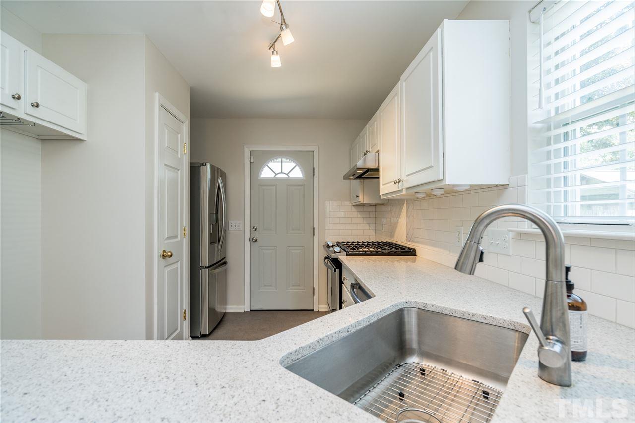 601 East Hargett Street Raleigh, NC 27601 - Photo 12 of 25 a kitchen with stainless steel appliances kitchen island granite countertop a refrigerator and a sink