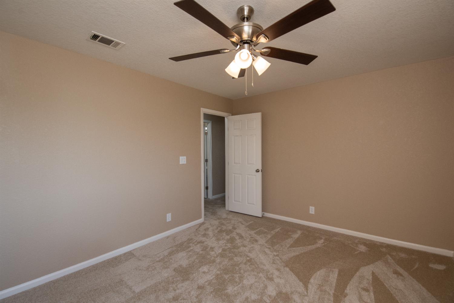 1621 Davis Street Ripon, CA 95366 - Photo 29 of 43 carpeted spare room with a textured ceiling and a ceiling fan