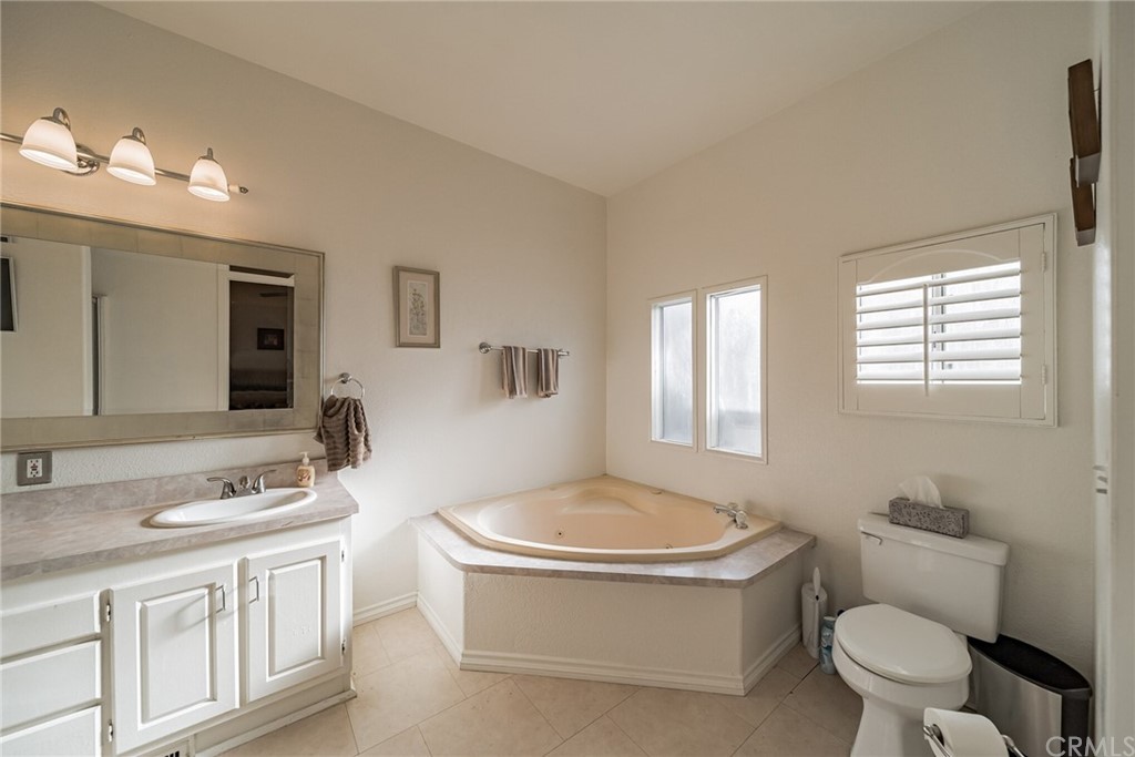 23301 Ridge Rte Drive, Unit 229 Laguna Hills, CA 92653 - Photo 17 of 26 a bathroom with a toilet a sink a tub and mirror