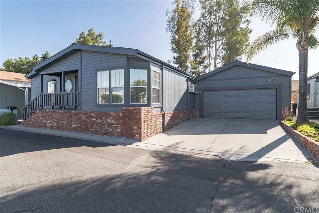 23301 Ridge Rte Drive, Unit 229 Laguna Hills, CA 92653 - Photo 19 of 26 a front view of a house with a yard and garage