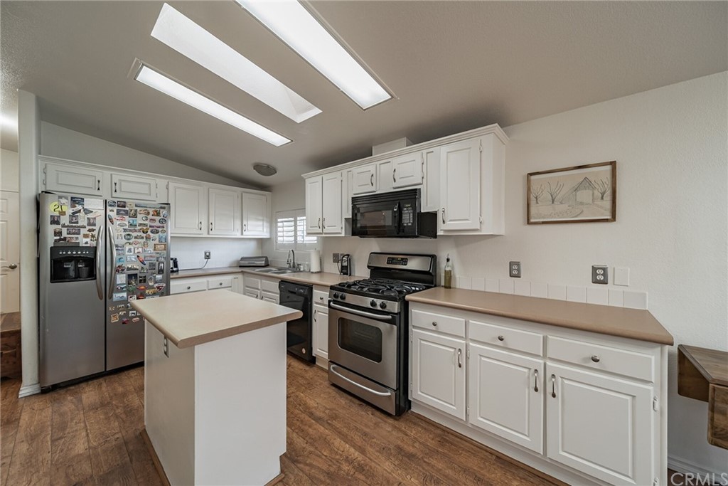 23301 Ridge Rte Drive, Unit 229 Laguna Hills, CA 92653 - Photo 7 of 26 a kitchen with white cabinets stainless steel appliances and sink
