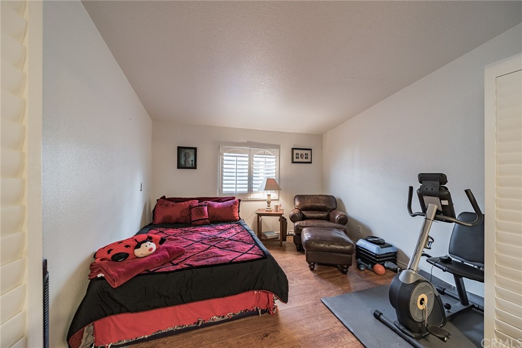 23301 Ridge Rte Drive, Unit 229 Laguna Hills, CA 92653 - Photo 9 of 26 a bedroom with a bed and wooden floor