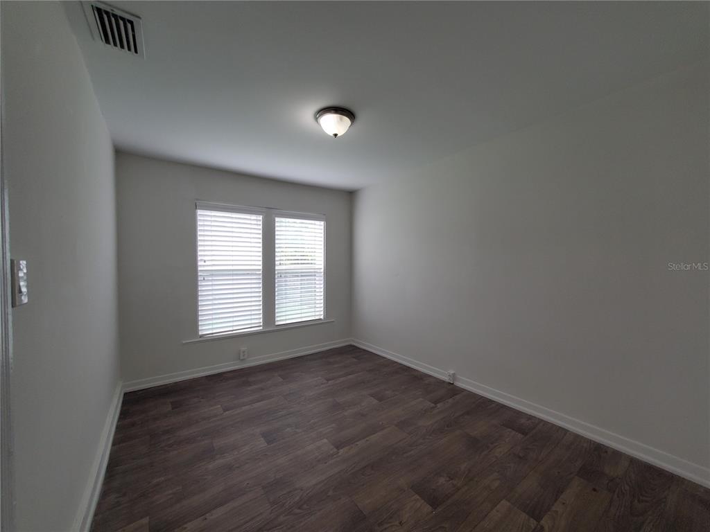 2703 West North A Street, Unit B Tampa, FL 33609 - Photo 5 of 10 an empty room with wooden floor and windows